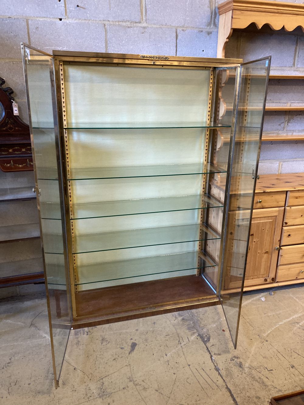 A gilt brass and plate glass collectors display cabinet, width 102cm, depth 33cm, height 162cm